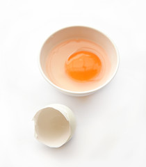 Egg york with egg shell on white small bowl