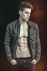 Handsome young man wearing leather jacket on naked torso