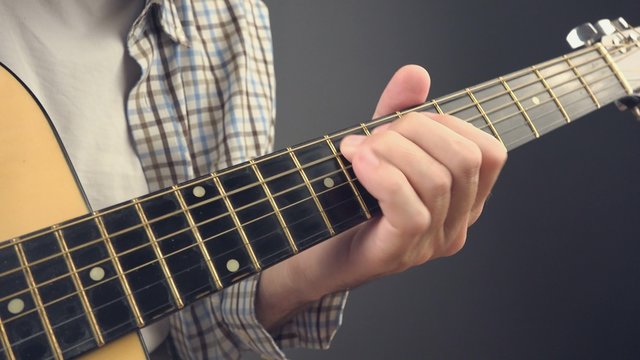 Man playing rock riff on acoustic guitar, unplugged blues rock music performance, close up, 4k uhd footage.
