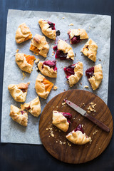 Assorted homemade pies pieces with pluots, apricots, sour cherries and flat peaches on the baking paper