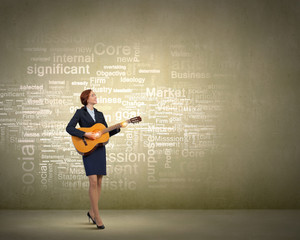 Businesswoman playing acoustic guitar