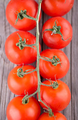 Tomatos on old wood background. Healthy and tasty food