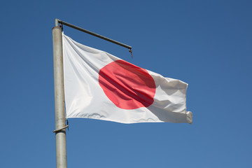 State Japanese flag on the  wind over blue sky background