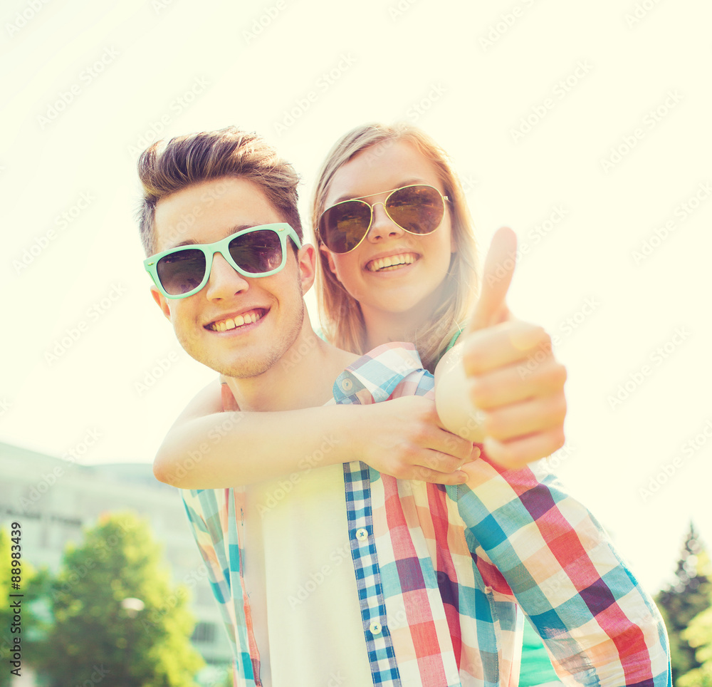 Wall mural smiling couple having fun and showing thumbs up