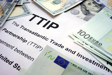 Word TTIP on a paper with dollars and euros.