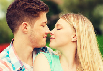 smiling couple touching noses in park