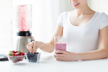 close up of woman with blender and milk shake