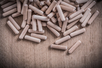 Collection of cylinder wooden dowel pins on wood board construct