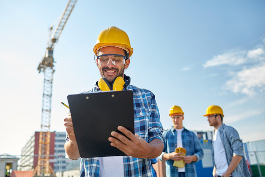 builder in hardhat with clipboard at construction