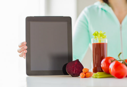 close up of woman with tablet pc and vegetables