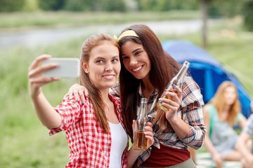 Fototapeta premium happy women taking selfie by smartphone at camping
