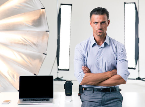 Confident businessman standing with arms folded