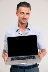 Businessman showing blank laptop computer screen