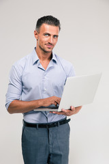 Portrait of a happy businessman using laptop