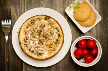 Banana caramel cheesecake on wooden background