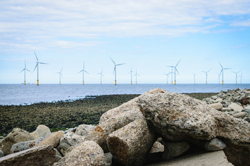 Stones on the beach and wind turbine background
