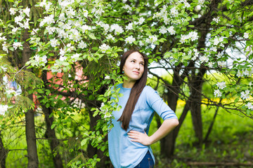 Portrait of spring brunette girl standing outdoor in blooming