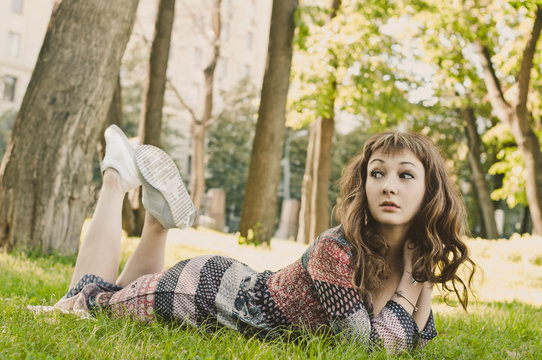 Beautiful girl lying on the grass in the park
