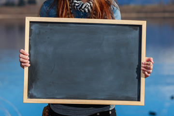 young woman holding a chalkboard