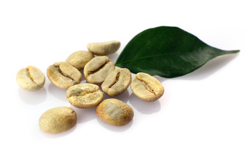 Heap of green coffee beans with leaf isolated on white