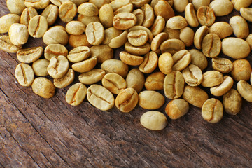 Heap of green coffee beans on table close up