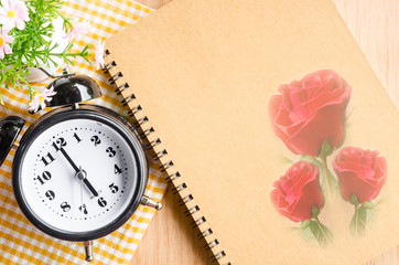 Clock diary brown color with red rose on wooden