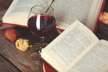 Beautiful composition with glass of wine with old books on table close up