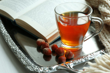 Cup of tea with book on metal tray, closeup