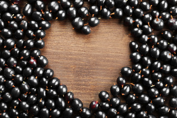 Heap of wild black currant on wooden table close up