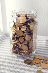 Coins in money jar on table close up