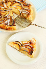 Homemade apple pie on plate, on white wooden table background background