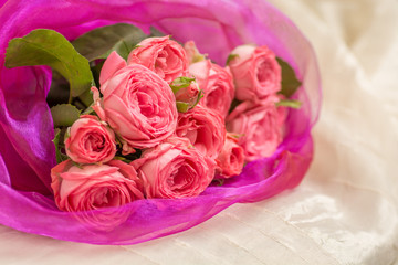 Wedding bouquet of pink roses in a beautiful lilac packaging