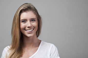 Photo of a beautiful young woman smiling cheerfully. Studio shot