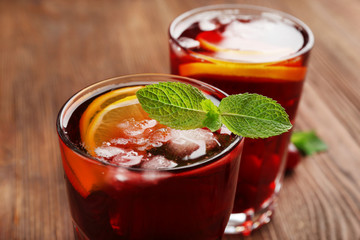 Glasses of cherry juice on wooden background