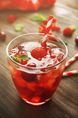 Glass of berry juice on wooden table, closeup