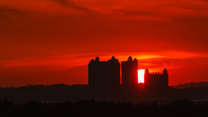 Obraz premium Beautiful Sunset Moment with Silhouette of Buildings