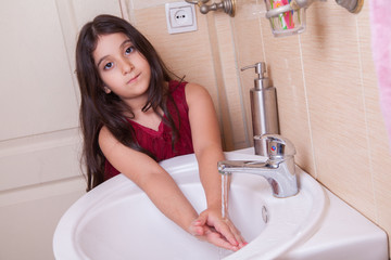 one beautiful little middle eastern arab girl with red dress is washing her hands in the bathroom.
Developed from RAW. retouched with special care and attention.