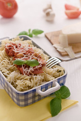 Italian homemade pasta with tomato sauce, basil and parmesan cheese. Concept of everyday dining.