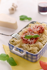Italian homemade pasta with tomato sauce, basil and parmesan cheese. Concept of everyday dining.