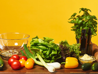 Fresh salad ingredients and yellow background