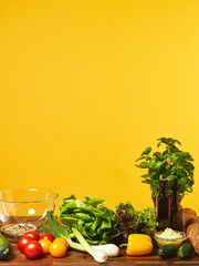 Fresh salad ingredients and yellow background