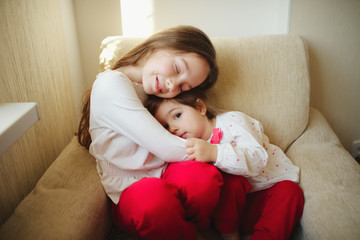 girl hugging her younger sister