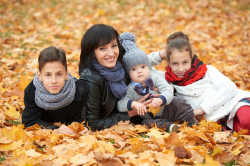 Fototapeta premium family in autumn park on yellow leaves
