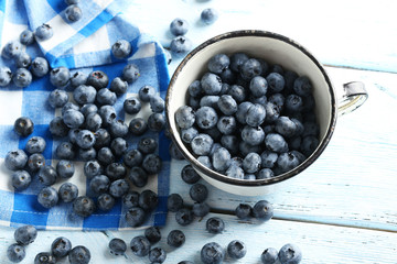 Blueberries in cup on a blue wooden background