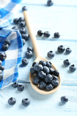 Blueberries in spoon on a blue wooden background