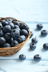 Blueberries in basket on a blue wooden background