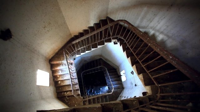 Dark spiral staircase with window into a lighthouse