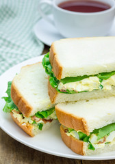 Sandwich with egg salad, bacon, green onion and lettuce
