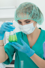 Medical doctor looking at flask with liquid in laboratory