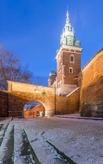 Winter morning view of the Sigismund bell tower of the Krakow cathedral on the Wawel Hill and main castle gate.